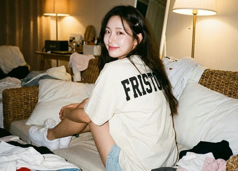 女生背对着观众坐在编织沙发上